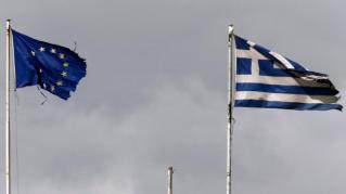 Frayed EU and Greek flags flutter atop the Greek Ministry of Finance in central Athens